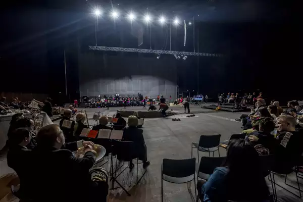 The South Warehouse during the Summer 2024 Artist Takeover, showing the performers and musicians in a circle around the central clay installation.