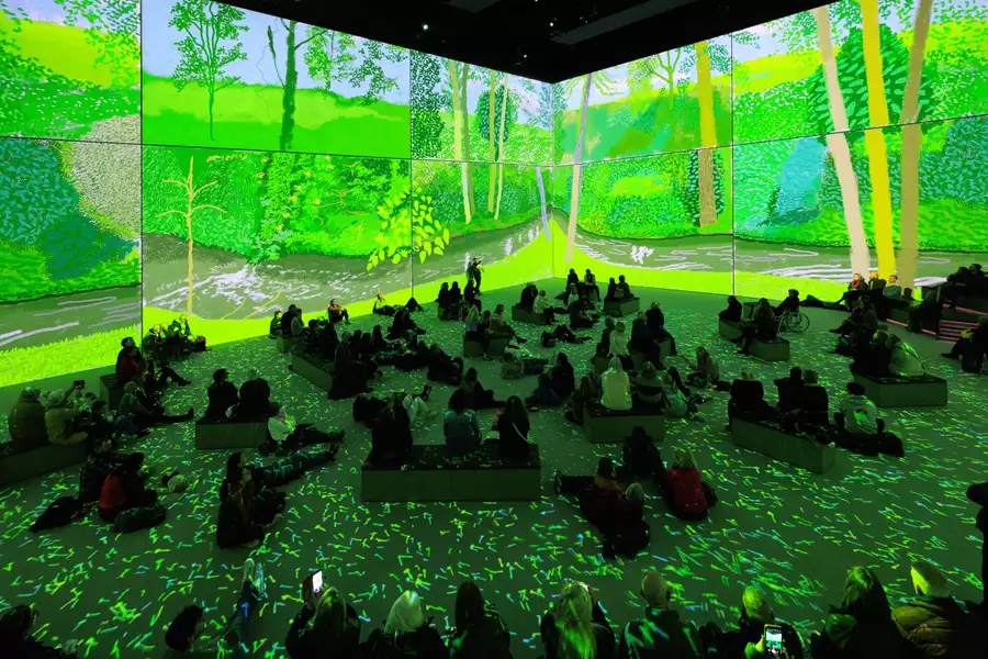 People sitting and lying on the floor in Aviva Studios watching Hockney's iPad paintings during Bigger & Closer (not smaller & further away)