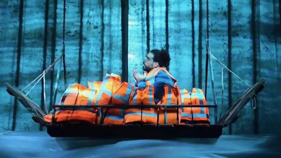 A person on stage in a boat with lifejackets