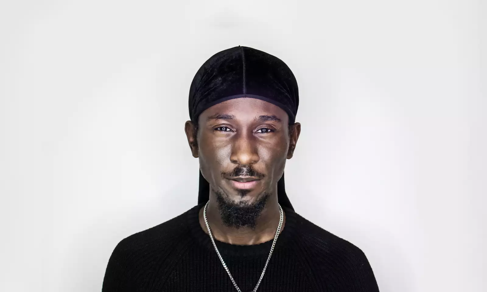 Portrait of Cephas Williams wearing black on a white background