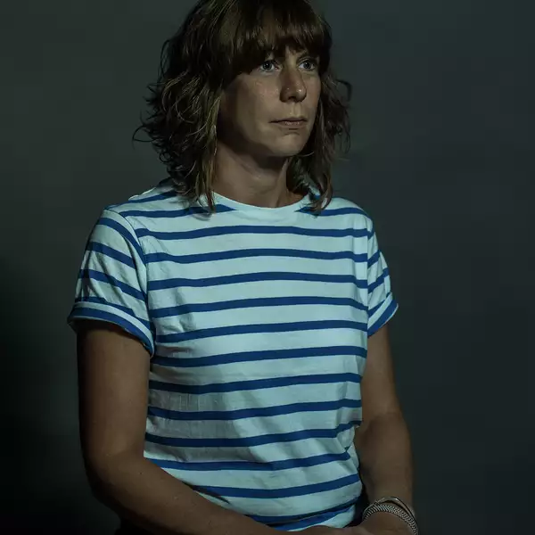 Headshot of Sarah Hardacre wearing a striped white t-shirt