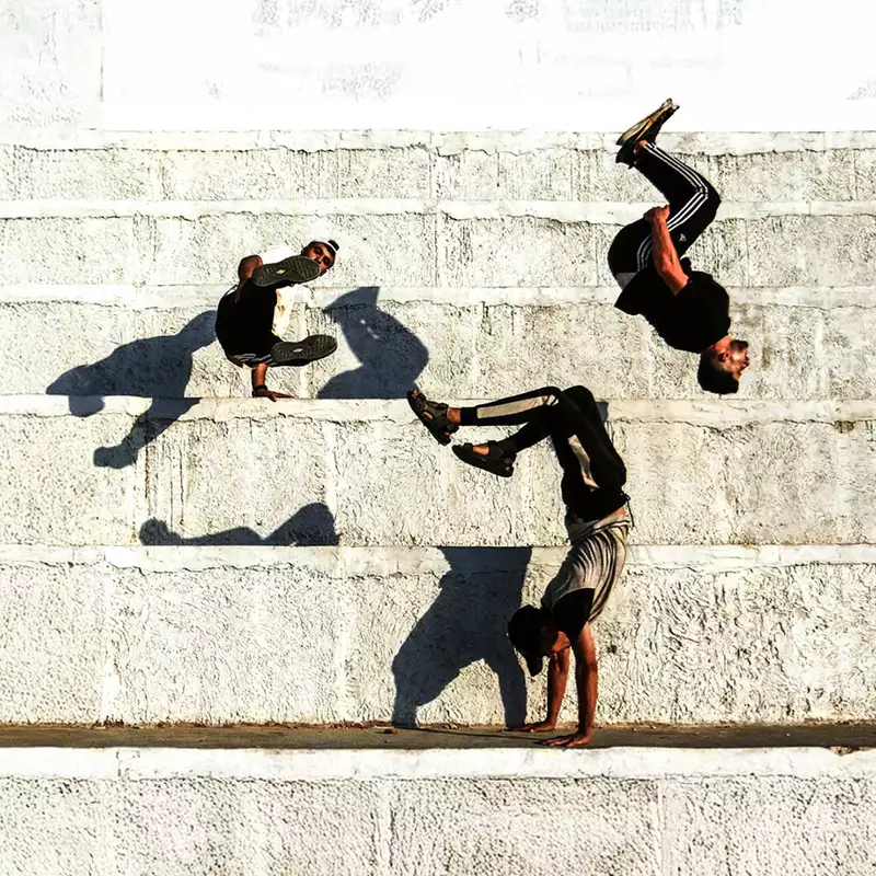 three people doing backflips against a wall