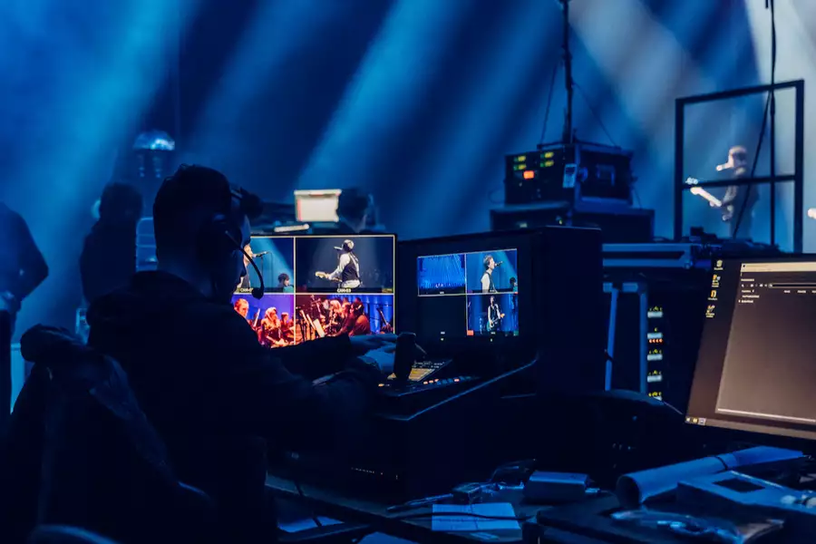 A technician working backstage at the Johnny Marr performance, managing live concert footage on computers.