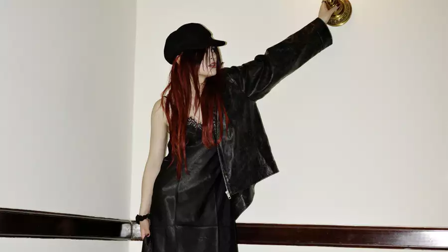 underscores wearing all-black outfit and hat