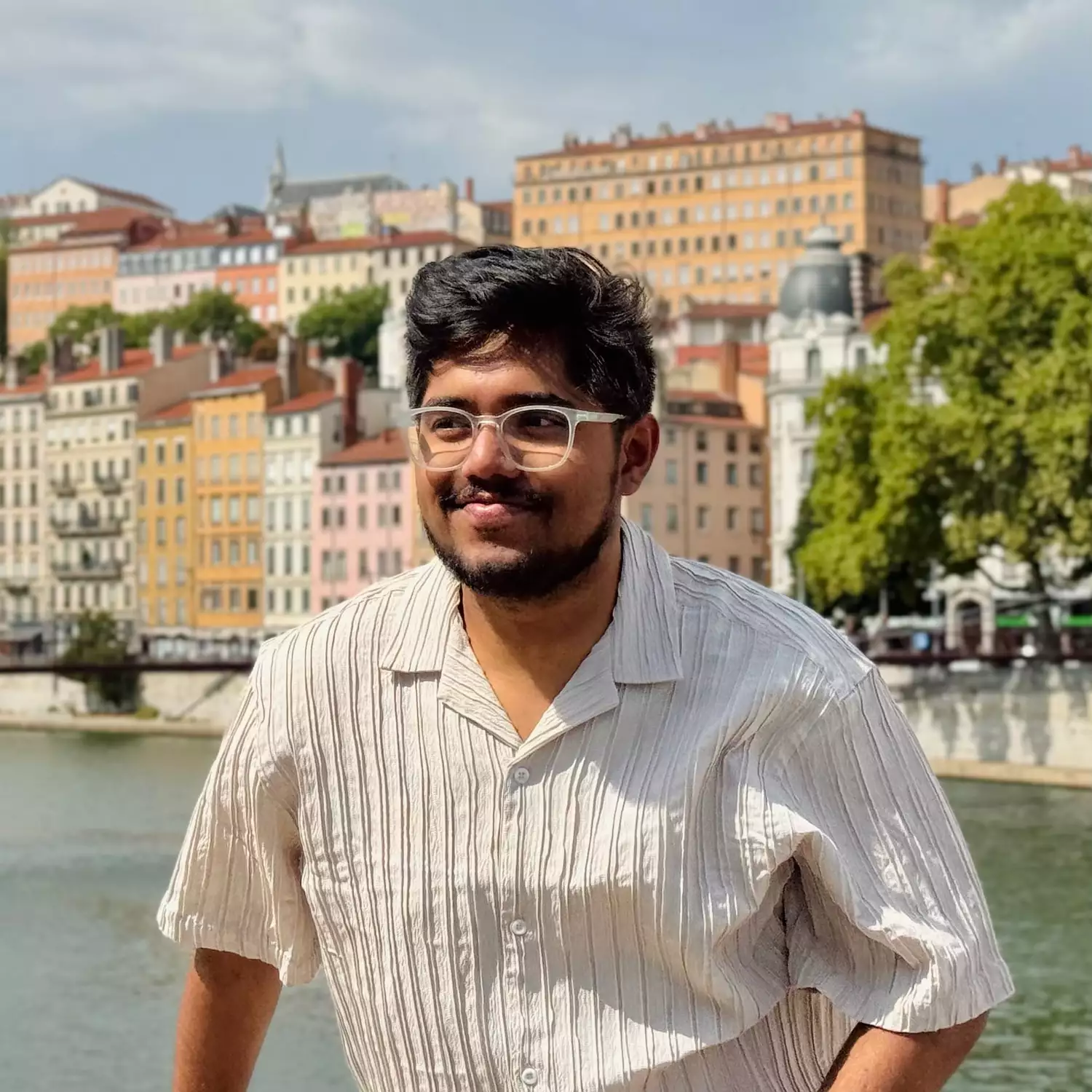Hadi Muhammad smiling by a river on a sunny day