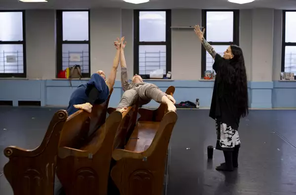 Sonya Tayeh directing two dancers during rehearsals for The Surge. They are performing on a pew.