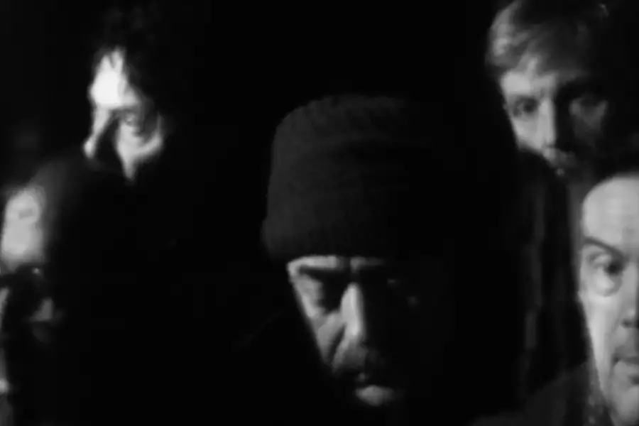 Black and white blurred photograph of the faces of five members of Tindersticks