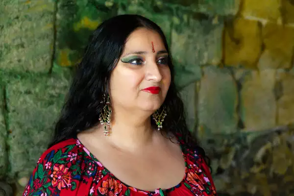Headshot of Satnam Galsian in side profile, stood in front of a stone wall
