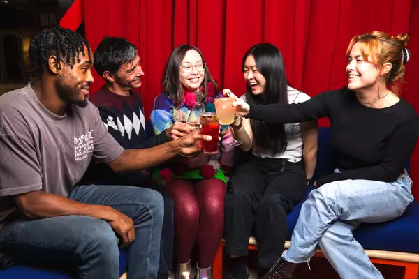 A group of people inside Aviva Studios drinking.