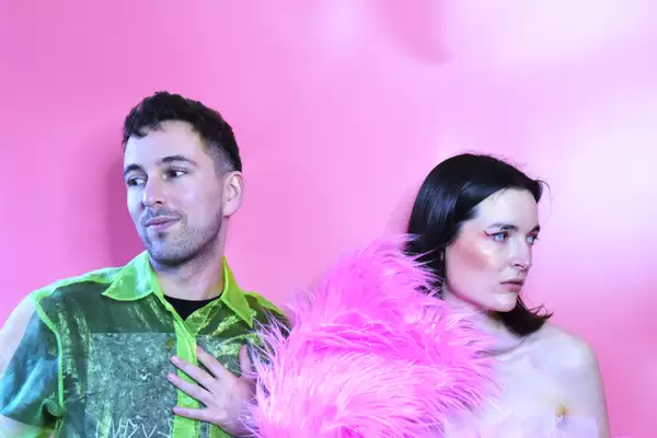 Headshot of Norrisette and Markus Hetheier on a bright pink background