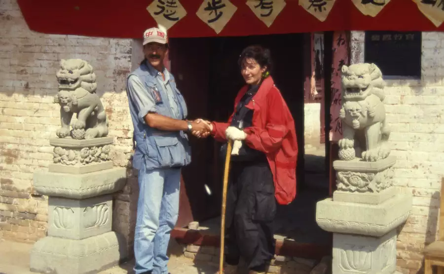 Marina Abramović and Ulay smiling and shaking hands on the Great Wall of China