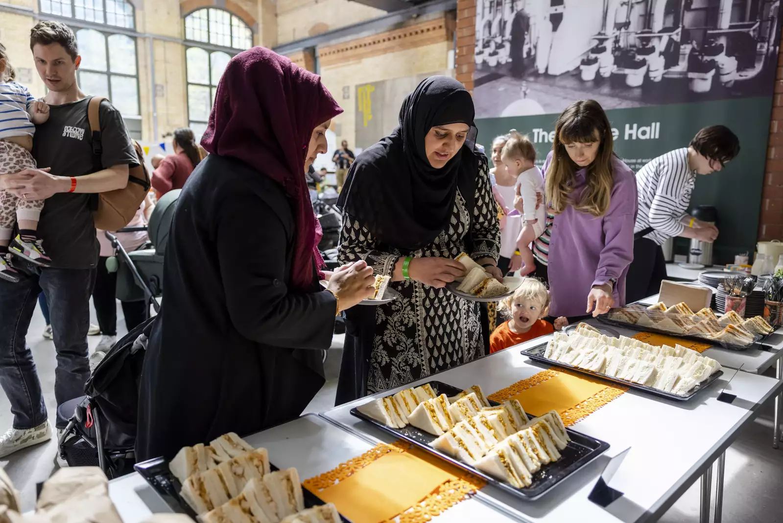 Parents/carers in discussion next to a table of sandwiches