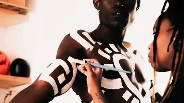 A woman painting a man with white body paint