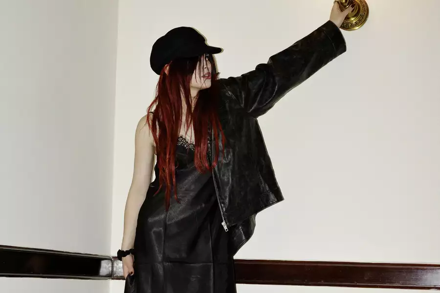 underscores wearing all-black outfit and hat