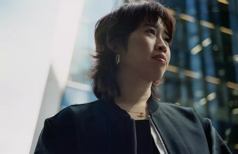 Headshot of Zing Tsjeng with a blurred glass building in the background