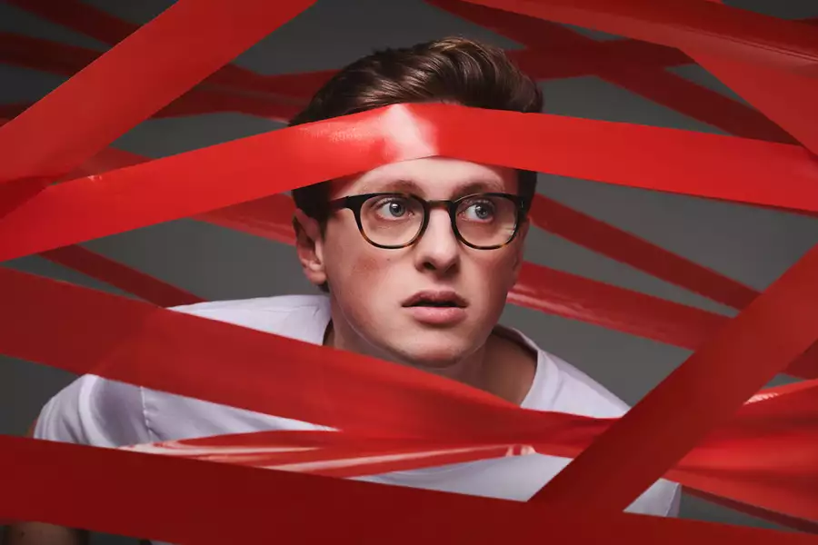 Max Fosh peering through red tape