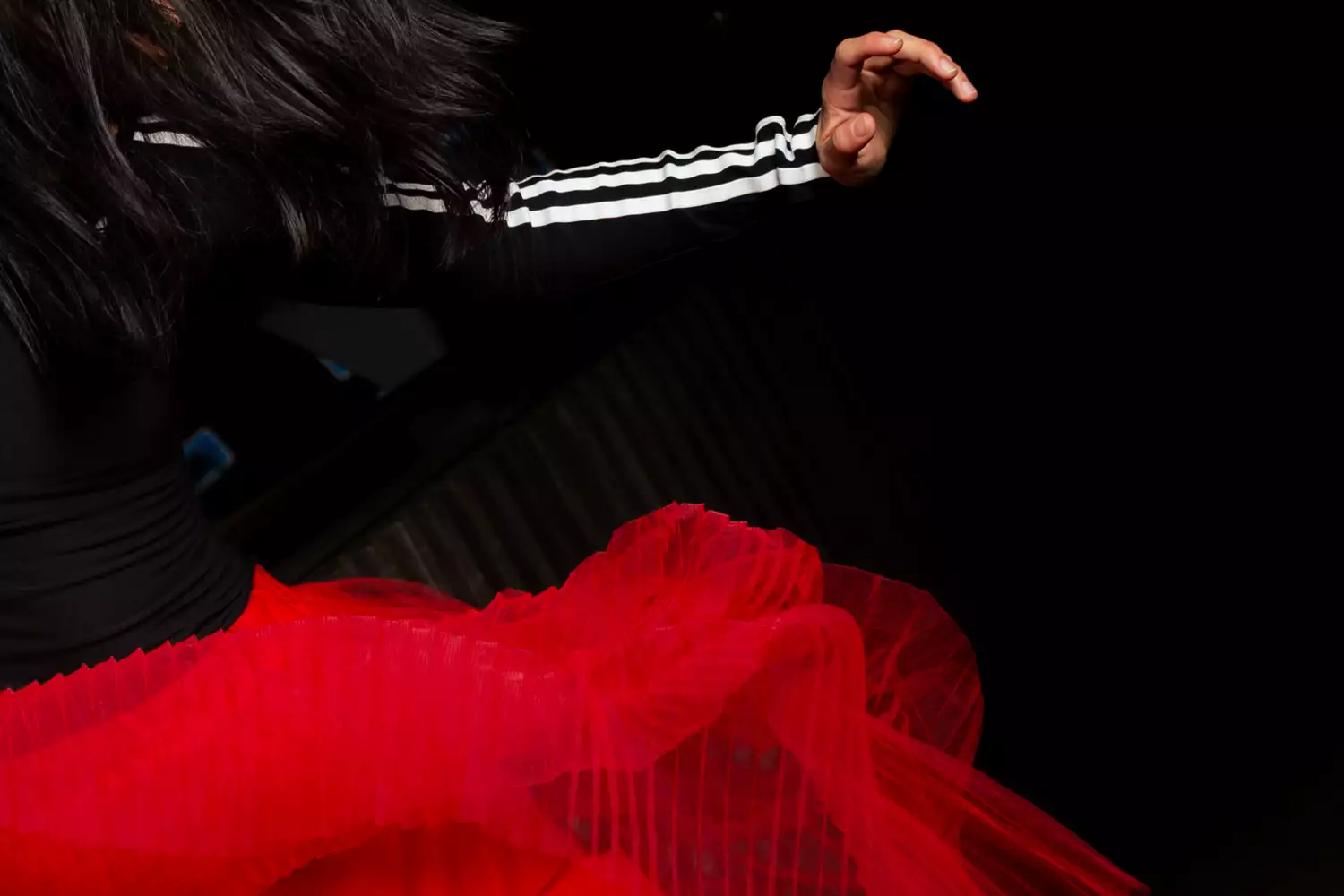 A dancer wearing a bright red material skirt