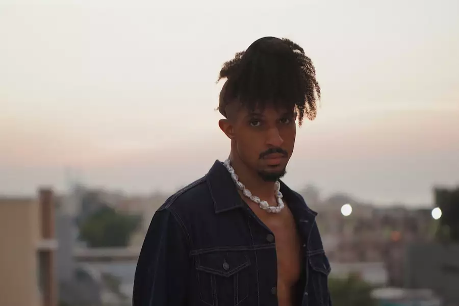 Maxi Zee stood on a roof at sunset