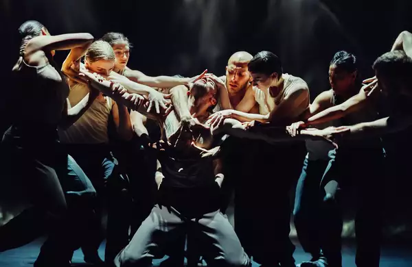 A still from Figures in Extinction [1.0] showing a performer being surrounded and grabbed by a group of performers