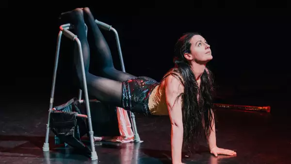 Porcelain Delaney performing on stage wearing black glittery shorts