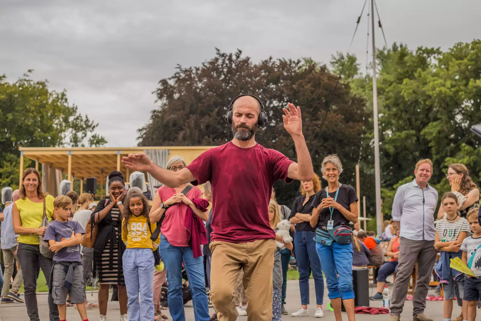 A group of dancers outside, some wearing headphones
