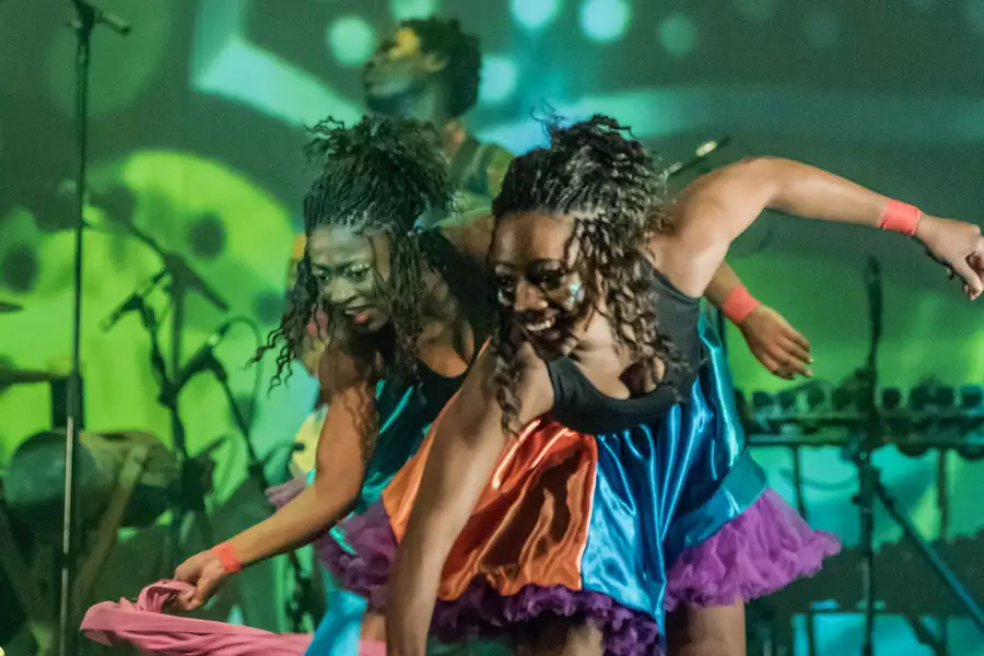 Photo of two dancers on stage dancing with colourful scarves