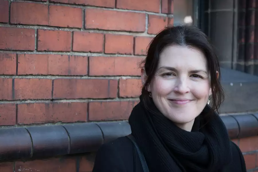 Philippa Vishnyakov smiling in front of a brick wall