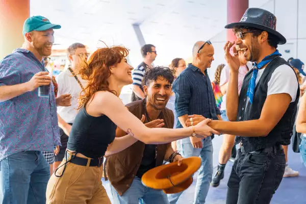 A group of people dancing and laughing outside in the Undercroft