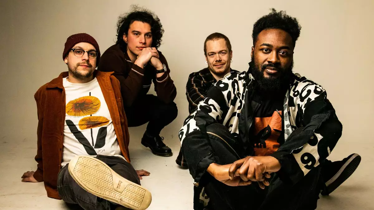 4 members of the band good grief relaxed sitting on the floor