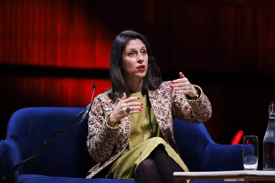 Nazanin Zaghari-Ratcliffe sitting in a blue chair and talking on stage at WOW festival