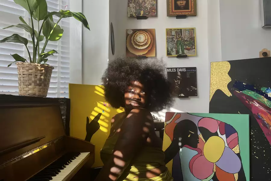 Misha B with paintings and a piano