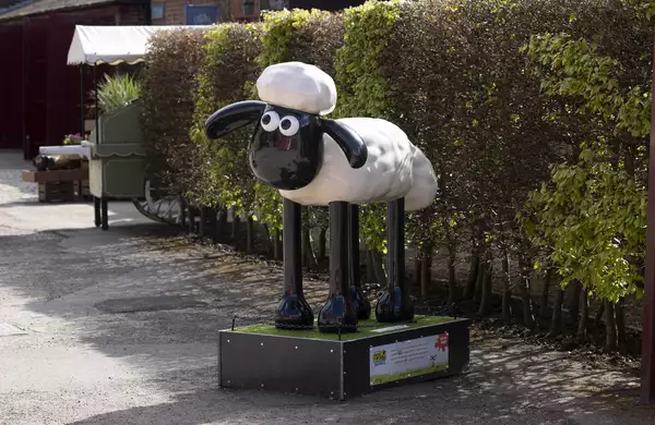 A Shaun the Sheep sculpture outside in a garden