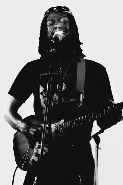 Black and white photo of Brandon Hinds singing and playing guitar