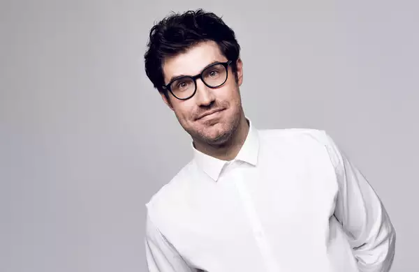 Headshot of Dan Schreiber on grey background