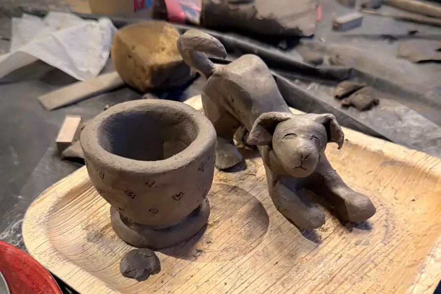 A clay tea light holder and dog
