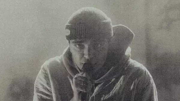 Grainy black and white photo of Ourkid singing into a microphone