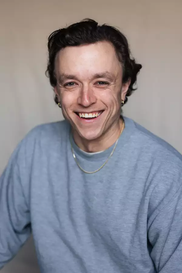 Joe Young in a grey sweatshirt and gold chain