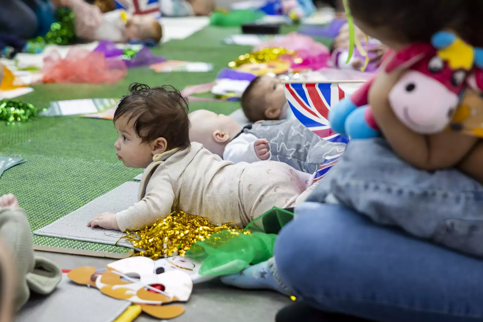 A baby lying on their tummy on a green mat