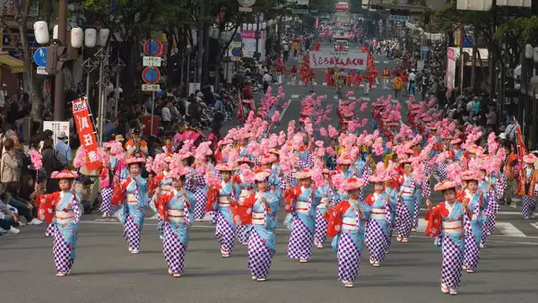 A parade of people dressed in bright, traditional Japanese dress