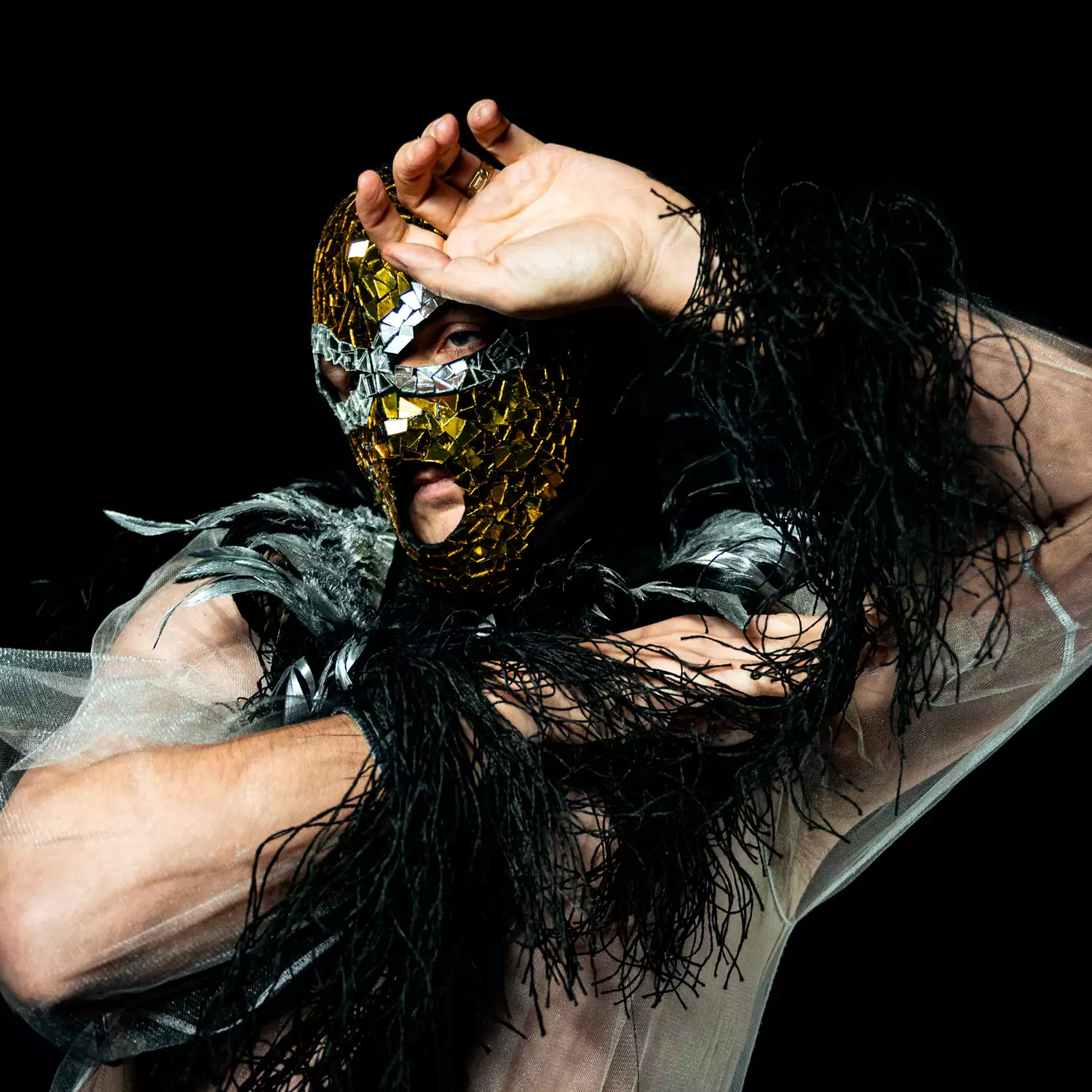 Kerian Jones wearing a glittered mask and feathers