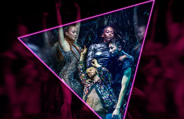 Neon-lit dancers posing inside a glowing triangle frame at a nightclub.