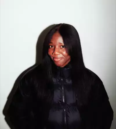 Rakhel Ojinnaka wearing a black Adidas puffer jacket on a white background