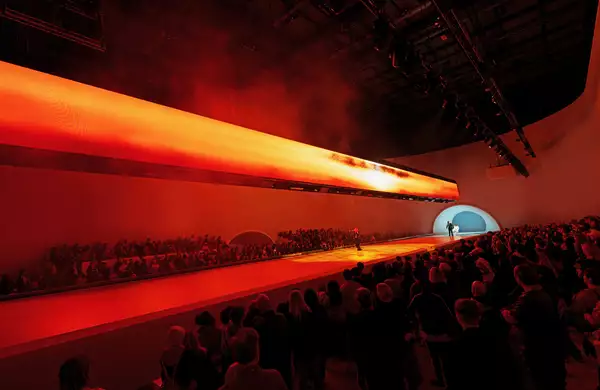 A crowd watching a dancer on stage during Free Your Mind in the Warehouse. The lighting is red.