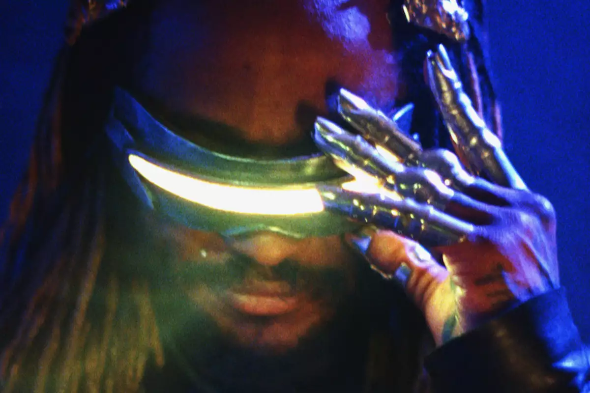 Thundercat wearing futuristic glowing visor glasses and metallic claw-like gloves against a dark blue background.