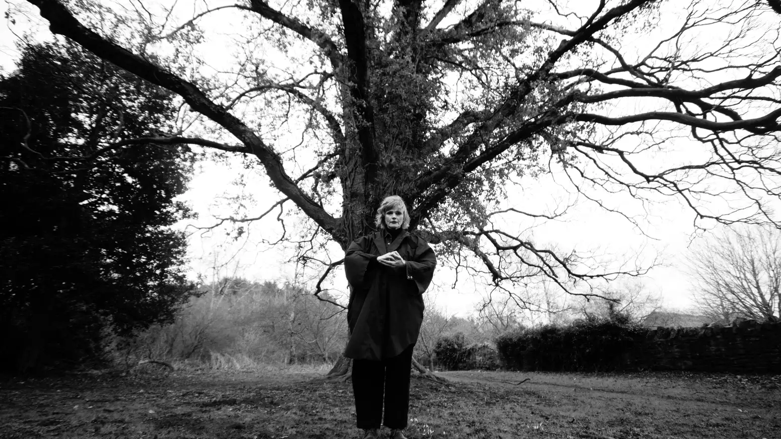 black and white photo of Maxine Peake stood in front of a large tree