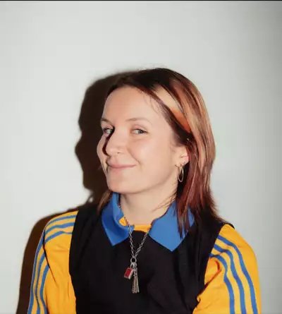 Rosa Fryer wearing a yellow and blue Adidas top on a white background