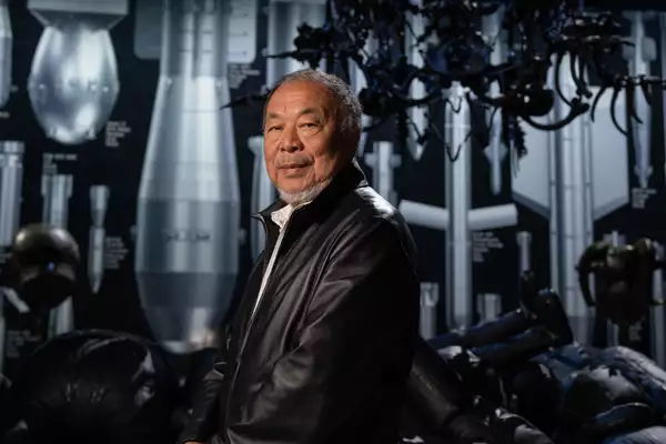 Ai Weiwei stood in front of History of Bombs – a giant artwork featuring 50 life-size bombs