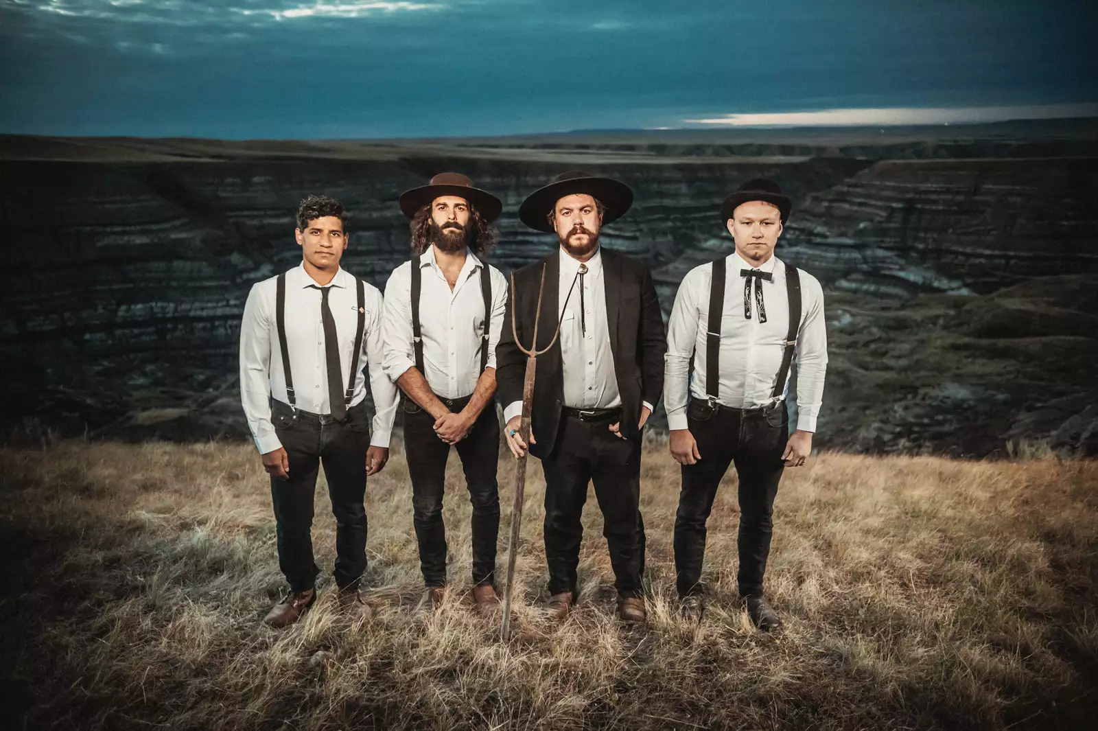 Four members of The Death South stood on a moor wearing suits