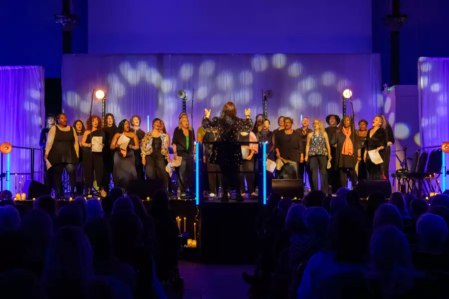 Nia Choir perform on stage bathed in purple lights
