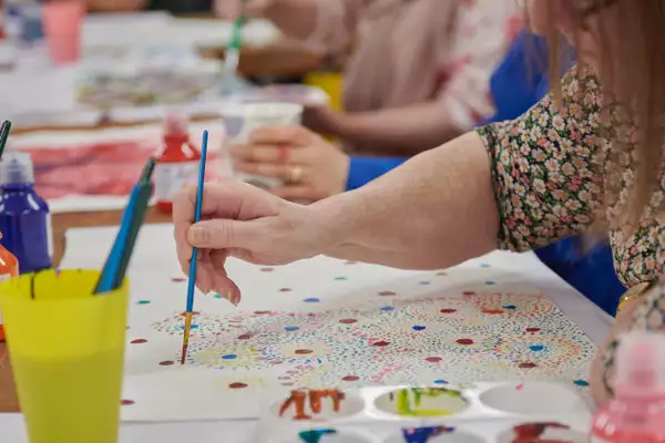 A person painting multicoloured dots